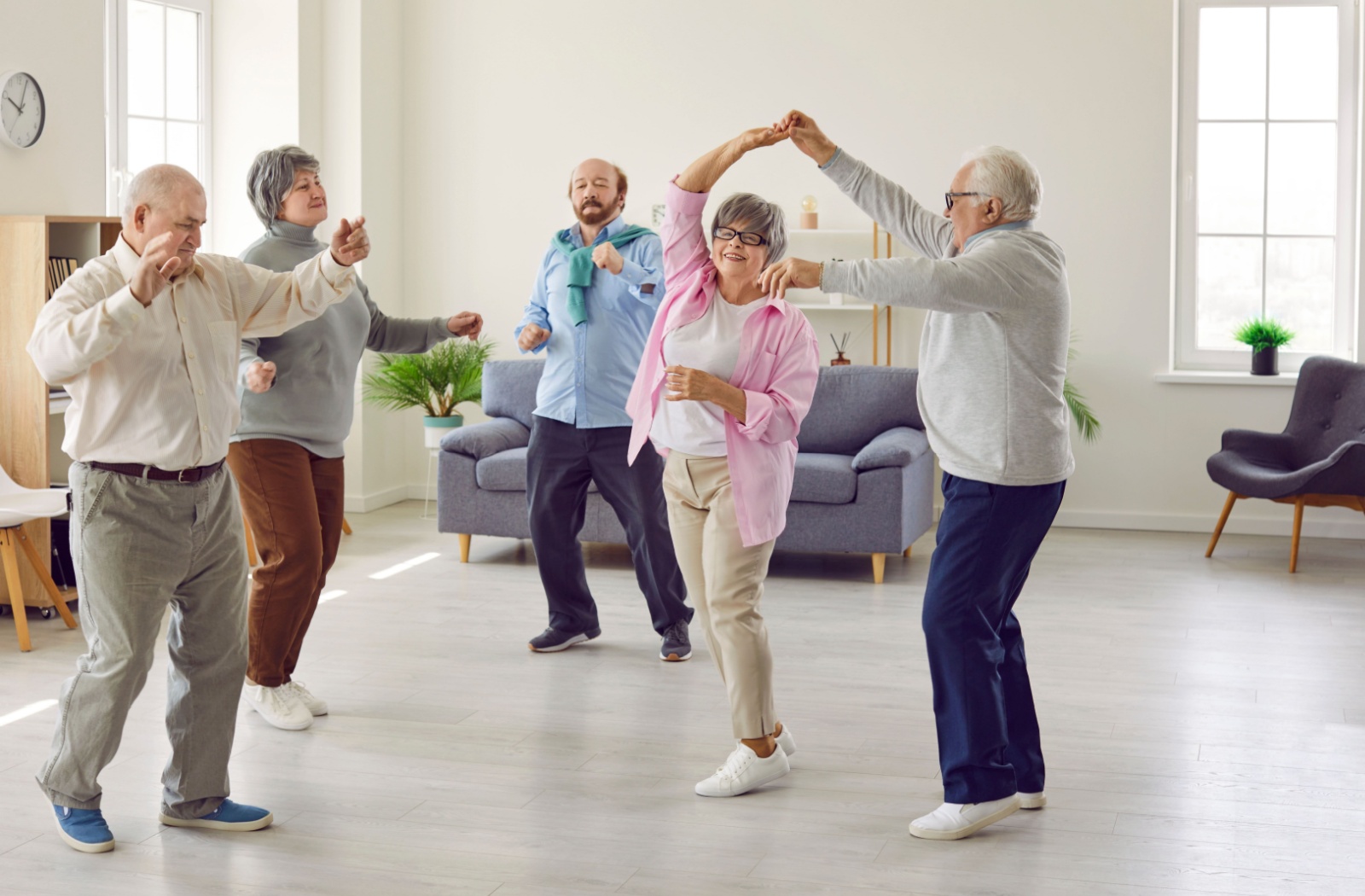 A group of seniors in memory care dance together
